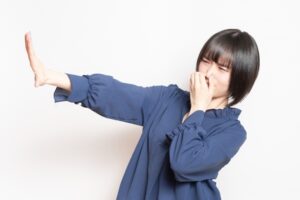 鼻をつまむ女性