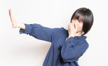 鼻をつまむ女性